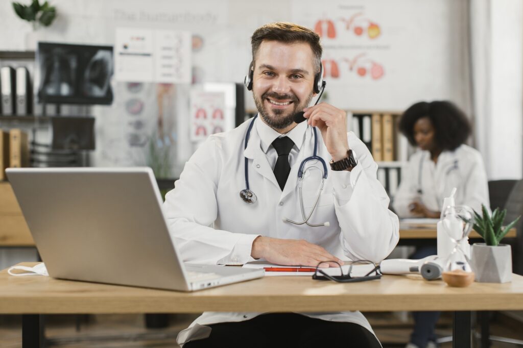 Doctor in headset having video call on laptop