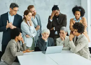 Group of young and senior business people having a meeting and being worried and stressed over a an AI project.